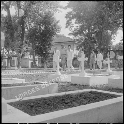 Le général de Castries, M. le Gouverneur du Nord-Vietnam, le général Cogny, M. Bordaz et M. Compain dans une allée d'un cimetière d'Hanoï.
