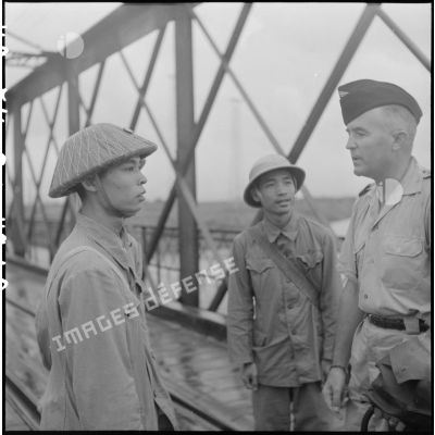 Conversation entre deux soldats de l'APVN (Armée populaire vietnamienne) et un officier du CEFEO (Corps expéditionnaire français en Extrême-Orient) sur le pont Paul-Doumer (aujourd'hui Long Biên).