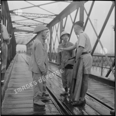 Conversation entre trois soldats de l'APVN (Armée populaire vietnamienne) et un officier du CEFEO (Corps expéditionnaire français en Extrême-Orient) sur le pont Paul-Doumer (aujourd'hui Long Biên).
