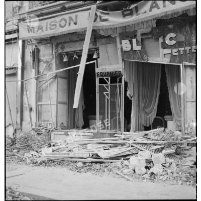 Devanture d'une boutique endommagée de la rue d'Isly après le bombardement allemand visant l'aérodrome Maison-Blanche à Alger, dans la nuit du 20 au 21 novembre 1942.