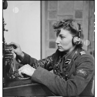 Portrait d'un lieutenant du corps féminin des transmissions utilisant un central téléphonique dans un centre de formation.