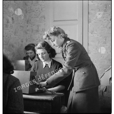 Un lieutenant du corps féminin des transmissions forme des élèves à la télétypie dans un centre de formation.