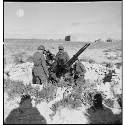 Des artilleurs du 411e RAAA (régiment d'artillerie antiaérienne) servent une mitrailleuse antiaérienne Hochkiss 13,2 mm sur affût bitube.