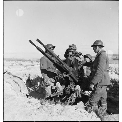 Des artilleurs du 411e RAAA (régiment d'artillerie antiaérienne) servent une mitrailleuse antiaérienne Hochkiss 13,2 mm sur affût bitube avec système de visée Le Prieur-Ricordel.