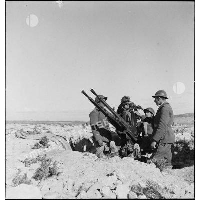 Des artilleurs du 411e RAAA (régiment d'artillerie antiaérienne) servent une mitrailleuse antiaérienne Hochkiss 13,2 mm sur affût bitube.
