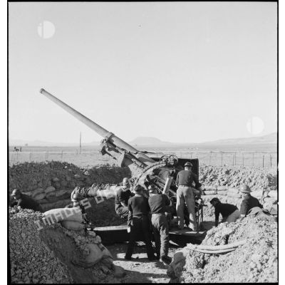 Des canonniers marins, d'une batterie mobile de 90 de marine, approvisionnent un canon de 90 mm, modèle 1939 Schneider antiaérien.