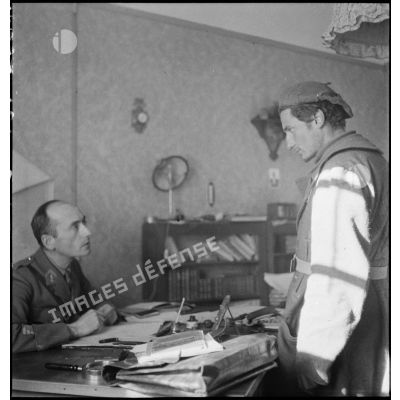 Interrogatoire d'un prisonnier italien par un capitaine dans un poste de commandement français.