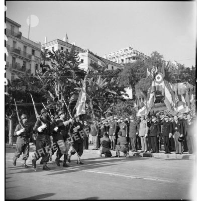 Défilé du drapeau et de la garde d'une unité de l'armée d'Afrique devant les autorités militaires lors d'une cérémonie franco-anglo-américaine au monument aux morts d'Alger.