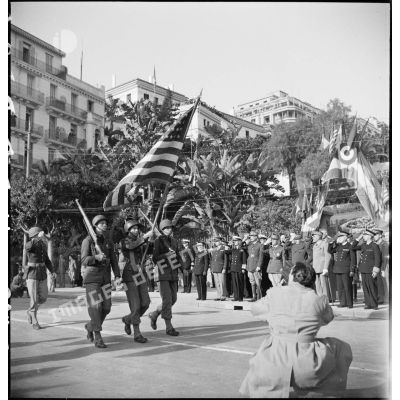 Défilé du drapeau américain et de sa garde devant les autorités militaires lors d'une cérémonie franco-anglo-américaine au monument aux morts d'Alger.