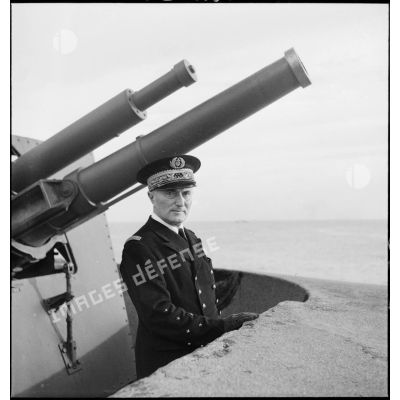 Portrait de l'amiral François Darlan, haut-commissaire de France en AFN (Afrique française du Nord), devant la tourelle d'une batterie de défense côtière dans le port d'Alger.