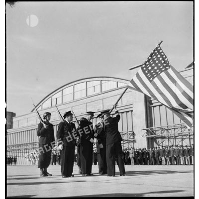 Pendant la cérémonie sur l'aérodrome de Maison-Blanche à Alger en l'honneur du GC II/5 La Fayette, le commandant Constantin Rozanoff, commandant le groupe de chasse, remet symboliquement le drapeau des Etats-Unis au lieutenant Pierre Le Gloan, porte-drapeau.