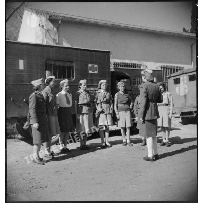 Un lieutenant féminin donne des ordres à un groupe de conductrices ambulancières du 27e escadron du Train avant un départ en mission.