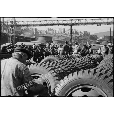 Stock de pneus de GMC en cours de gonflage par des civils à la chaîne de montage des camions d'Oran.