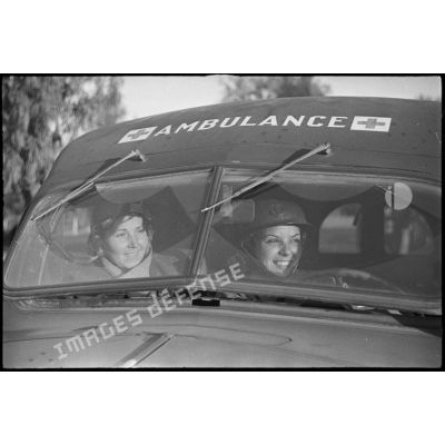 Portrait de groupe de deux volontaires féminines conductrices à la 521e compagnie sanitaire à bord d'une ambulance Dodge T215.