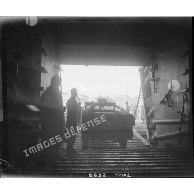 Embarquement d'un scout-car français sur un bâtiment de transport américain d'hommes et de matériel.