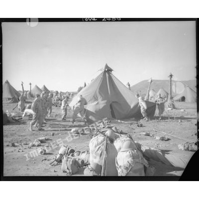 Dans un campement, les hommes plient les tentes avant l'embarquement pour l'Italie.