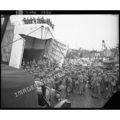 Des hommes du corps expéditionnaire français (CEF) patientent avant leur embarquement à bord d'un landing ship tanks (LST) à destination de l'Italie.