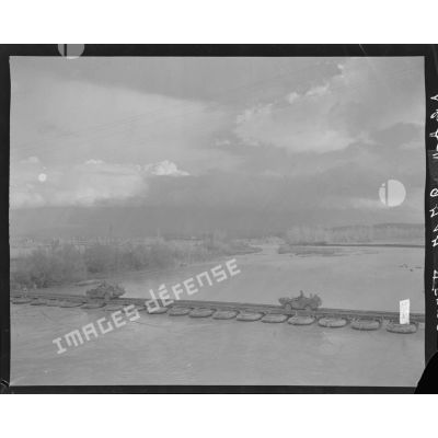 Passage de convois de scouts-cars et amphibies sur un pont de radeaux pneumatiques.
