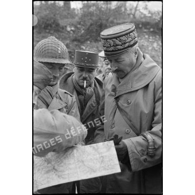 Le général Giraud et le général Juin s'entretiennent avec un officier qui leur montre une carte.