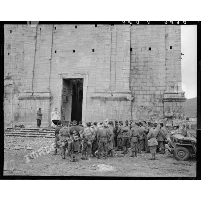 Des tirailleurs du 5e RTM (régiment de tirailleurs marocains) de la 2e DIM (division d'infanterie marocaine) assistent à la messe de Noël, célébrée par un aumônier militaire catholique sur le parvis de l'église d'un village situé à proximité des premières lignes italiennes.