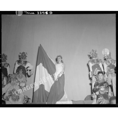 L'artiste Gisèle Grandpré, drapée dans un drapeau tricolore, chante La Marseillaise lors du tableau final du gala de l'Empire.