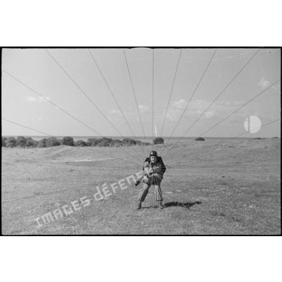 Le parachutiste manoeuvre ses suspentes pour diriger son parachute.