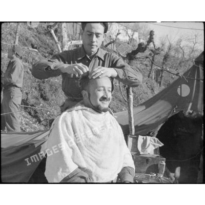 Un soldat se fait couper les cheveux.