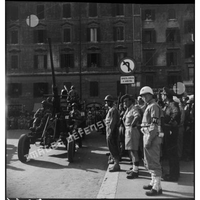 Canon antiaérien Bofors de 40 mm tracté par un camion GMC défilant dans une rue de Rome. du 40e groupe autonome colonial des forces terrestres antiaériennes.