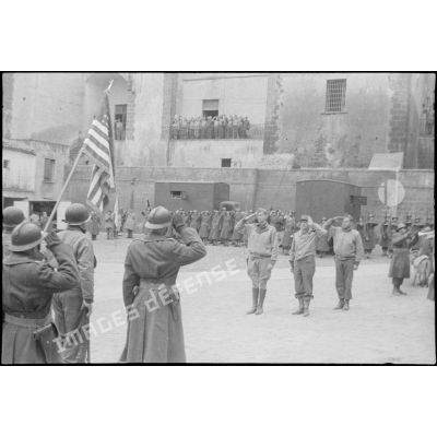 Le général Clark et le général Juin saluent les drapeaux français et américains.