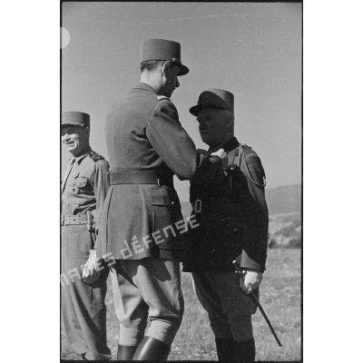 Le général de Gaulle décore le général de Monsabert de la croix de la Libération.