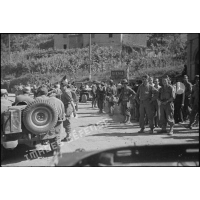Les soldats et la population civile de Sienne laissent passer un convoi de jeeps.