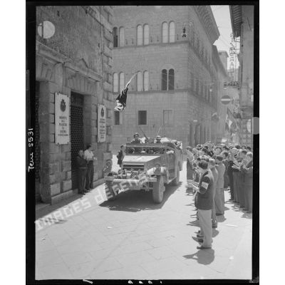 Un scout-car d'une unité du corps expéditionnaire français (CEF) circule dans Sienne sous les applaudissements de la population civile.