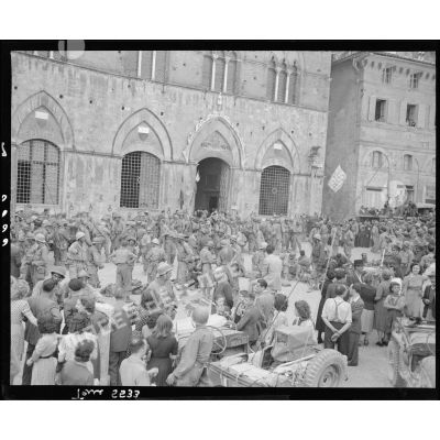 Des tirailleurs de la 3e division d'infanterie algérienne (3e DIA) sont mêlés à la population devant l'hôtel de ville avant une cérémonie sur la Piazza del Campo.