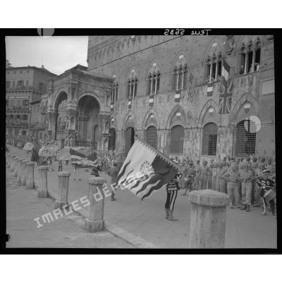 Les bannières des différents quartiers de Sienne défilent sur la Piazza del Campo à l'issue d'une cérémonie rassemblant les troupes du corps expéditionnaire français (CEF).