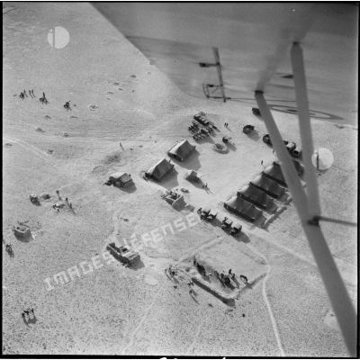 Vue aérienne d'une oasis et d'un campement militaire.