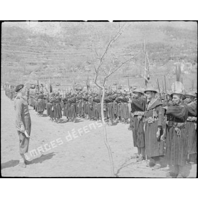 Dans le secteur du Garigliano, le général d'armée Alphonse Juin, commandant le CEFI (Corps expéditionnaire francais en Italie), qui préside une cérémonie d'hommage aux soldats tombés pendant la campagne, salue le fanion du 8e tabor marocain.