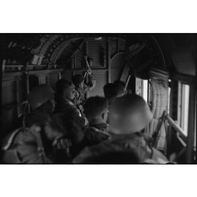 Des parachutistes de la 1.Fallschirm-Jäger-Division s'équipent de leur parachute avant de monter à bord d'un avion de transport Junkers Ju-52.