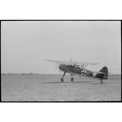 Sur un terrain d'aviation occupé par la 1re escadre aéroportée (Luftlandegeschwader 1), décollage de l'avion Henschel Hs-126 codé H4+NW.