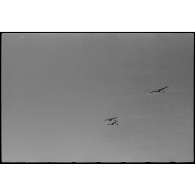 Lors d'une mission aéroportée du Sondergruppe du Luftlandegeschwader 1, trois planeurs DFS-230 viennent de larguer le câble qui les reliait au biplan Avia B.534.
