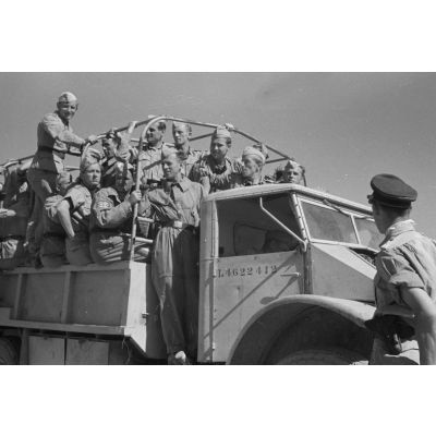 En Libye, des équipages de Junkers Ju-87 rejoignent un terrain d'aviation à bord d'un camion britannique capturé.