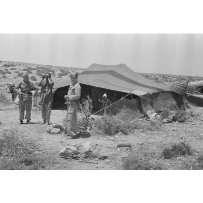 Après un repas sous la tente des bédouins, deux aviateurs échangent avec les bergers avant de quitter la tente.