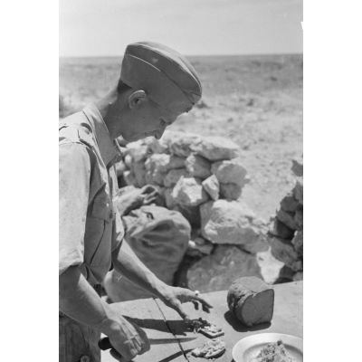 De retour de patrouille dans le désert libyen, deux aviateurs se préparent un repas sur une cuisine roulante.