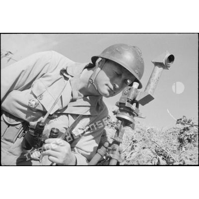 Un officier de tir de l'Armée B, équipé de jumelles et d'un binoculaire, à son poste d'observation installé à proximité du fort Lomont.