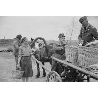 A l'entrée d'une exploitation agricole de la région de Smolensk, un Sonderführer de la Luftwaffe et un sous-lieutenant de la 1re compagnie de propagande contrôlent la sortie de denrées réquisitionnées.