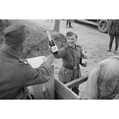 Dans un magasin d'approvisionnement, une bouteille de Champagne ou de mousseux (Sekt) est présentée à un soldat sur sa charrette.