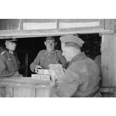 Sous la surveillance d'un lieutenant, la récupération du ravitaillement dans un magasin de l'armée de terre.