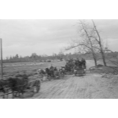 Une colonne de réfugiés croise un semi-chenillé Leichte Flak Abteilung 71 (11.Panzer-Division) dont on aperçoit les insignes.