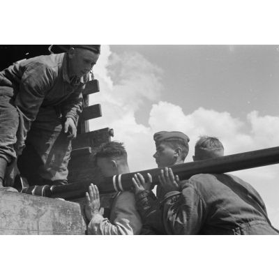Lors du mouvement d'une batterie de FlaK, des artilleurs chargent le tube d'un canon de 3,7 cm FlaK 18.