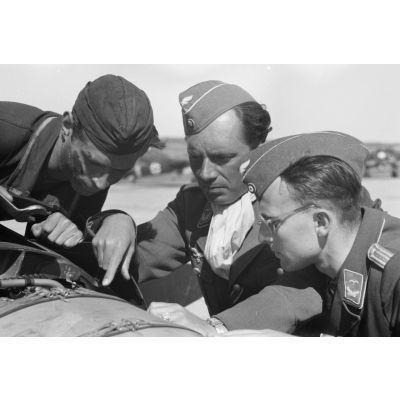 Un mécanicien et deux officiers s'affairent sur l'un des moteurs BMW d'un bombardier Ju-88 du Kampfgeschwader 3 Blitz.