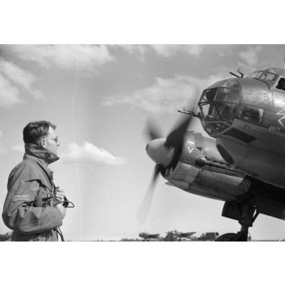 Un lieutenant, reconnaissable à son grade cousu sur la manche droite, observe le bombardier Junkers Ju-88 codé 5K+EP appartenant au Kampfgeschwader 3 Blitz (6.KG3 ou III./KG3).